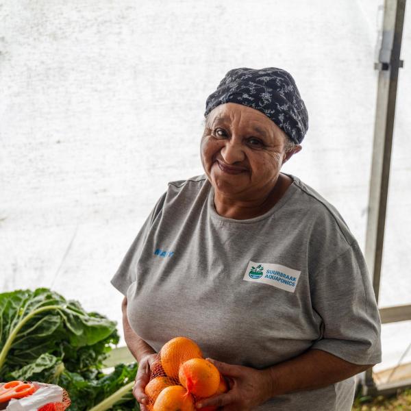 A farmer holding produce in their hands.