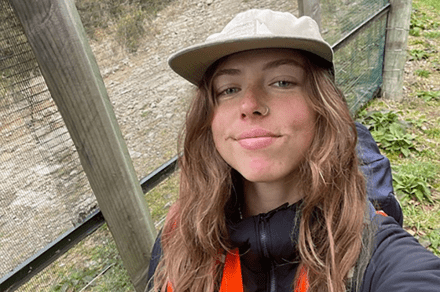 Georgia stands in front of a fence