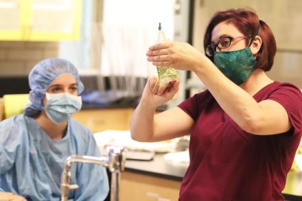 A student in a classroom watching an instructor fill a prescription bottle