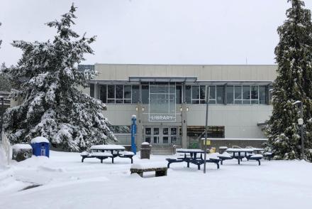 A view of VIU's Nanaimo campus library from the exterior with a snowed-in quad